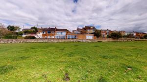 a field of grass with houses in the background at Meadow View in Crawley