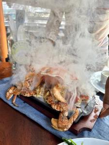 a smoking lobster on a tray on a table at Daffodil Restaurant & Holiday Resort in Unawatuna