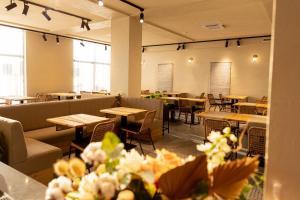 a dining room with tables and chairs and windows at Complex Acom in Baile Felix