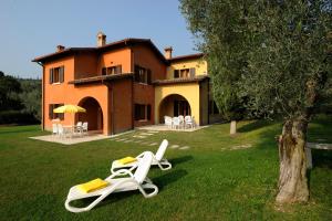 ガルダにあるPoiano Garda Resort Appartamentiの家の前の芝生の上に座るラウンジチェア2脚