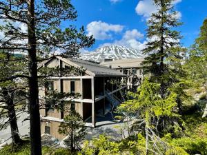 an exterior view of a house with a snow covered mountain in the background at Gausta View Lodge in Gaustablikk