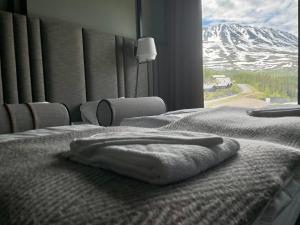 a bed in a room with a snow covered mountain at Gausta View Lodge in Gaustablikk