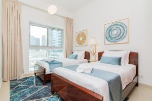 pokój hotelowy z 2 łóżkami i oknem w obiekcie Cozy 2BR Delux Apartment in Dubai Marina w Dubaju