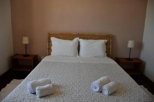 - une chambre avec un lit et des serviettes dans l'établissement Alojamentos Vitinho 3 for Walkers, à Vila Nova de Milfontes