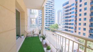 a balcony with chairs and plants and buildings at Cozy 2BR Delux Apartment in Dubai Marina in Dubai