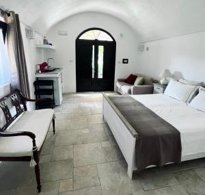 ein Schlafzimmer mit einem großen Bett und einem Sofa in der Unterkunft Le Lamie di Ostuni in San Michele Salentino