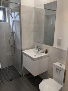uma casa de banho com um chuveiro, um lavatório e um WC. em Lennox by Cush Realty em Acra