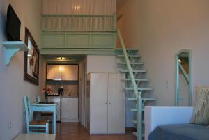 a living room with a staircase and a kitchen at Lefkanthemo in Astypalaia