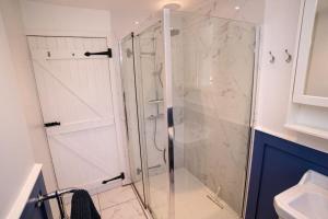 a shower with a glass door in a bathroom at Beautiful Country Cottage in Hayfield +25 photos