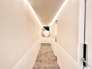 un pasillo de un pasillo con paredes blancas en 东京上野超豪华4人间 东京超级中心设计师房间Ycod 上野公园3分钟 车站1分钟 超级繁华 免费wifi 戴森吹风, en Tokio
