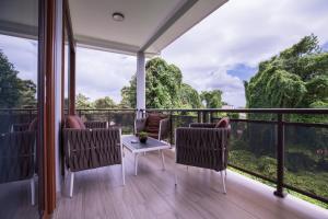 a room with a balcony with a table and chairs at Waterlily Guesthouse in Beau Vallon
