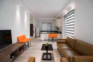 a living room with a brown couch and orange chairs at Waterlily Guesthouse in Beau Vallon