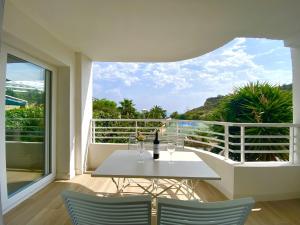 d'une table blanche et de deux chaises sur un balcon. dans l'établissement La Caleta By Gloove, à La Vila Joiosa