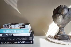 Ein Stapel Bücher und eine Vase auf dem Tisch in der Unterkunft Walton Lane in Oxford