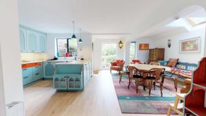 a kitchen and living room with blue cabinets and a table at Thames View In Oxford in Oxford