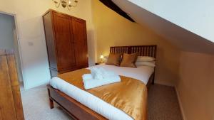 a bedroom with a bed with a wooden headboard at Market Place Cottage in Woodstock