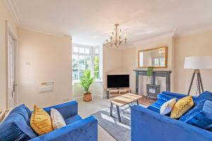 a living room with blue couches and a fireplace at Bay Cottage in Malpas
