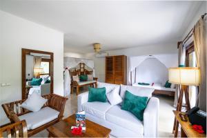 a living room with a white couch and green pillows at White Paradise Zanzibar in Pongwe