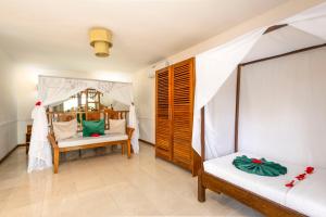 Cette chambre comprend un lit, un canapé et une chaise. dans l'établissement White Paradise Zanzibar, à Pongwe