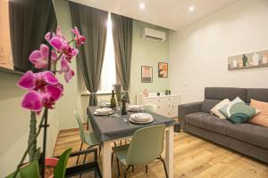 - un salon avec une table et un canapé dans l'établissement Porto Antico Exclusive Apartment, à Gênes
