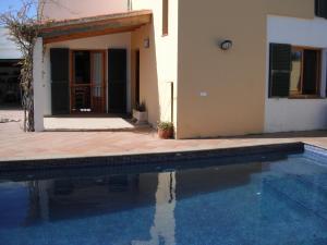 a house and a swimming pool in front of a house at Casa familiar con piscina, cerca de la playa in Ciutadella
