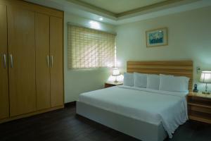 una camera con un grande letto bianco e due lampade di Peniel Apartments ad Abuja