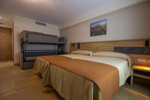 1 dormitorio con 1 cama grande y una pintura en la pared en Hostal Las Grullas en Tornos