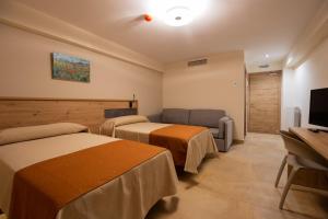 um quarto de hotel com duas camas e uma televisão em Hostal Las Grullas em Tornos