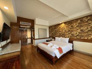 a bedroom with a bed and a stone wall at Ritz Boutique Hotel in Pattaya South