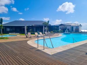 a swimming pool with chairs and a deck at Hills Intweshe in Ballito