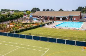 a large pool with a tennis court next to a tennis court at Hoburne park Bluebell10 in Burton