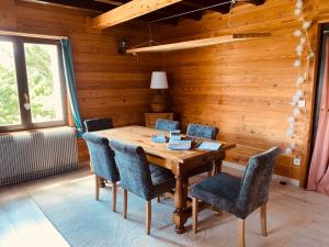 comedor de madera con mesa y sillas de madera en Gite la maison du bonheur, en Eygliers