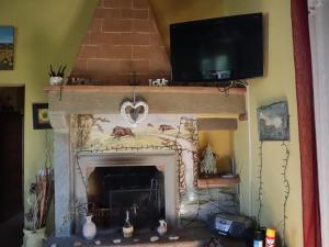 a living room with a fireplace with a tv above it at English Garden Cortona in Cortona