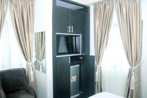 a black cabinet with a tv and a chair in a room at SILVERZB RESORT in Iseyin