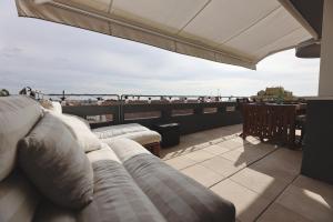 a balcony with couches and a view of the ocean at Boavista Sunlit Duplex with Terrace in Porto