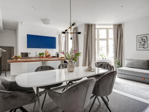 a living room with a white table and chairs at Sanders City - Spacious studio apartment in Copenhagen