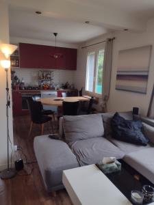 uma sala de estar com um sofá e uma mesa em Charmante maison em Dinard