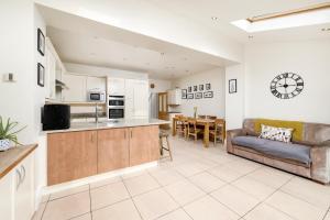 cocina y sala de estar con sofá y mesa en Modern 3 bedroom house with garden view, en Londres