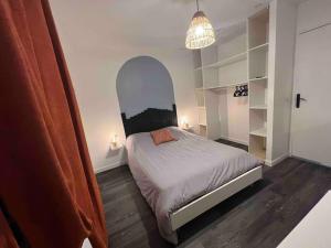 ein Schlafzimmer mit einem Bett und einem Torbogen in der Unterkunft Appartement cosy proche du centre in Reims
