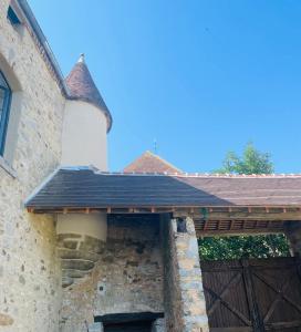 um edifício com um portão de madeira e uma parede de pedra em Le Saint Léonard em Montceaux-lès-Provins