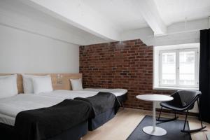 a bedroom with a bed and a brick wall at Original Sokos Hotel Villa Tampere in Tampere