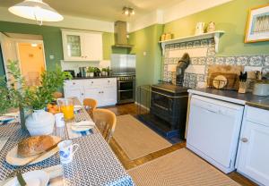 a kitchen with a table with a table cloth on it at Plas Lligwy Cottage in Moelfre