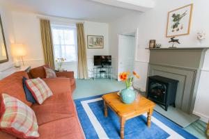 a living room with a couch and a fireplace at Plas Lligwy Cottage in Moelfre