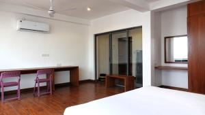 una camera da letto con 2 sedie viola e una scrivania di City Beds Negombo a Negombo