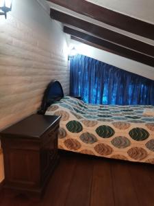 a bedroom with a bed and a blue curtain at La Granja de Papá Alberto in Puembo
