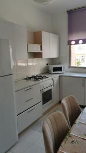a kitchen with white cabinets and a stove top oven at Rix Hostel in Kyrenia