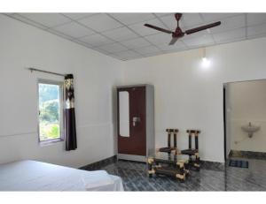 a bedroom with a bed and a ceiling fan at Manas View Jungle Resort, Assam in Jyoti Gaon