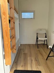 a room with a wooden staircase and a chair at Idrætscenter Jammerbugt in Fjerritslev