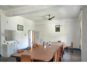 a dining room with a large wooden table and chairs at Manas View Jungle Resort, Assam in Jyoti Gaon