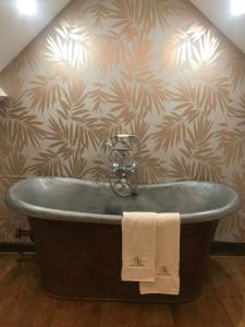 a bath tub in a bathroom with a wall at Le Saint Leonard in Montceaux-lès-Provins